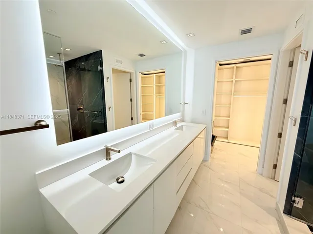 a kitchen with a sink a refrigerator and white cabinets