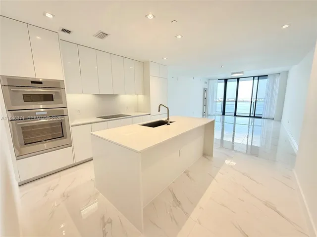 a view of a kitchen with an empty space and a window