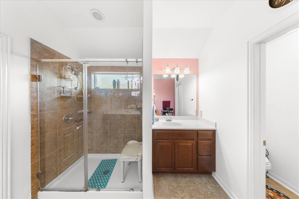 349 Razzmatazz Trail Buda, TX 78610 - Photo 25 of 27 A well-appointed bathroom features a large walk-in shower and a spacious vanity.