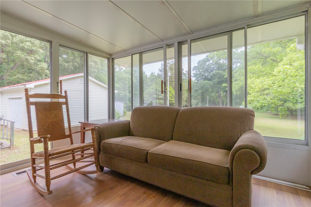 This bright sunroom offers serene views of the surrounding natural landscape, perfect for relaxation.