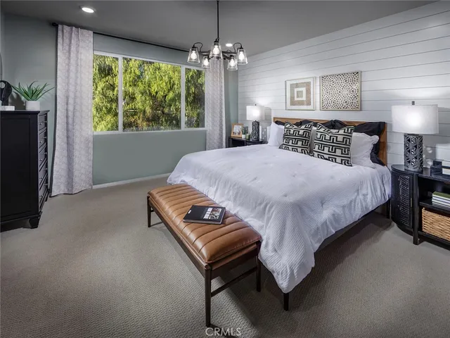 a bed sitting in a spacious bedroom next to a window