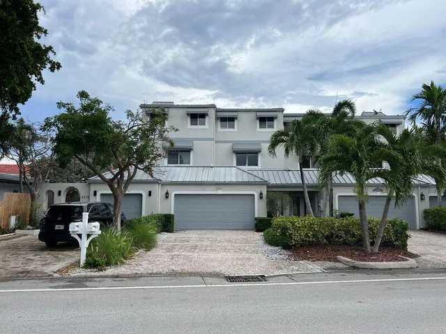 a front view of a house with a garden and plants