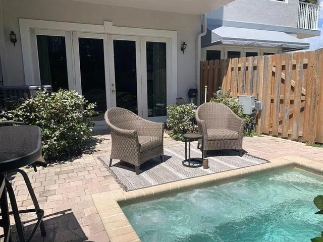 a building outdoor space with patio furniture and potted plants