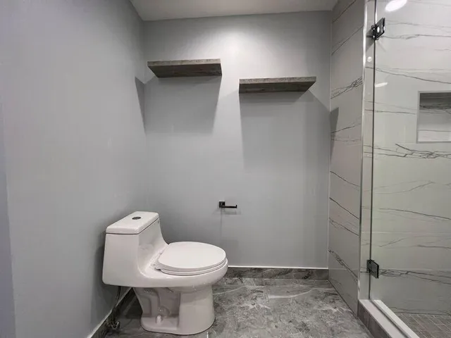 a bathroom with a shower a toilet and a sink