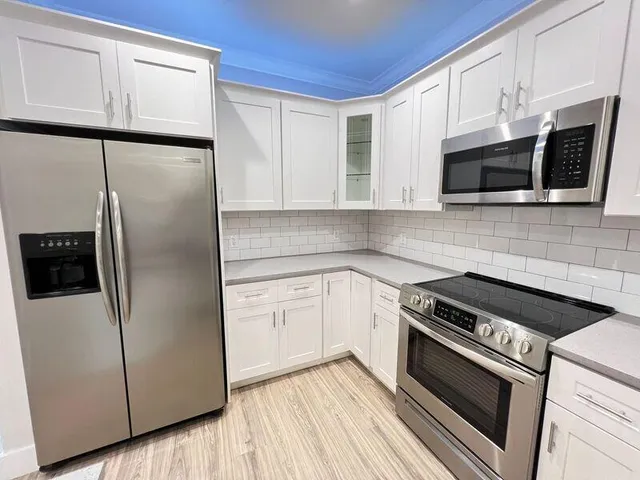 a kitchen with stainless steel appliances a refrigerator sink and microwave