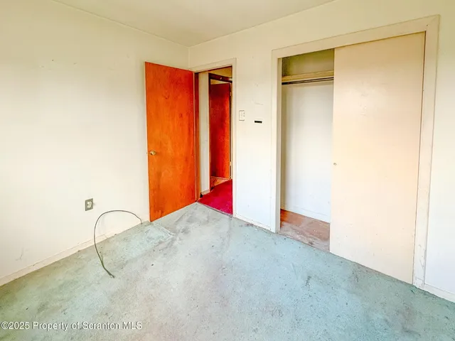 en empty room with windows and ceiling fan