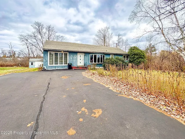a front view of a house with a yard and outdoor seating