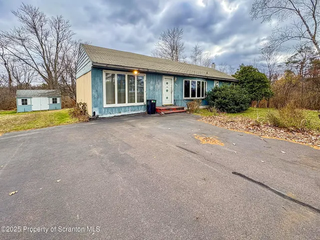 a view of a house with a patio and a yard