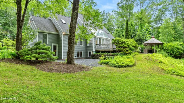 a view of a big house with garden and plants