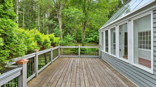a view of backyard with deck and wooden floor