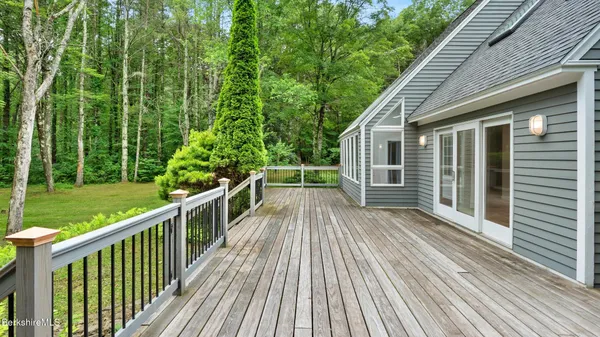 a kitchen with stainless steel appliances granite countertop a stove a sink and white cabinets with wooden floor