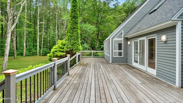 a kitchen with stainless steel appliances granite countertop a stove a sink and white cabinets with wooden floor