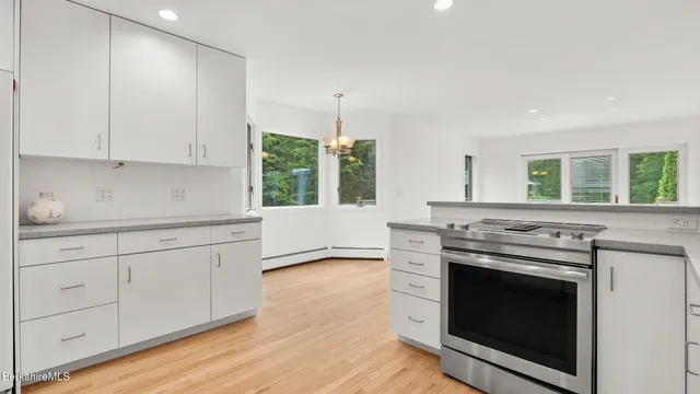 a view of an empty room with wooden floor fireplace and a window