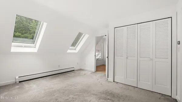 a bathroom with a toilet a window and a shower