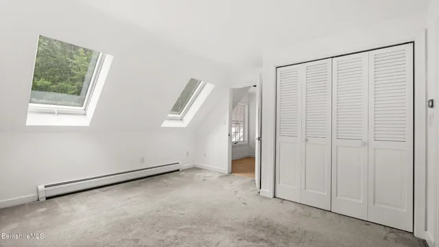 a bathroom with a toilet a window and a shower