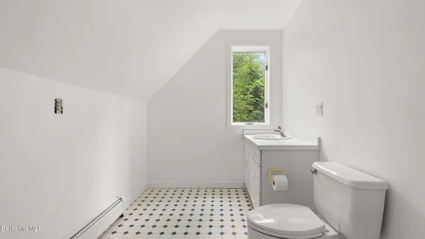 a bathroom with a toilet a window and a shower