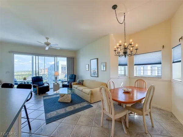 a living room with furniture a flat screen tv and a large window