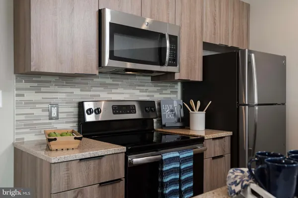 a kitchen with stainless steel appliances a refrigerator and a stove top oven