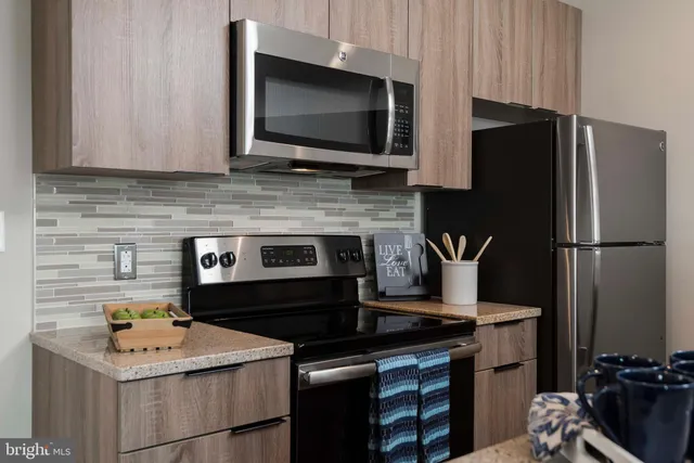 a kitchen with stainless steel appliances a refrigerator and a stove top oven