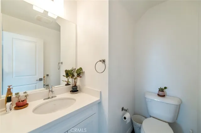 a bathroom with a granite countertop toilet sink and mirror