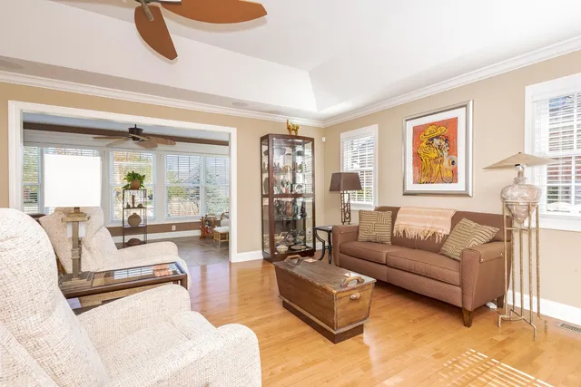 a living room with furniture kitchen view and a window