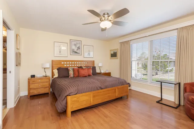 a bedroom with a large bed and wooden floor