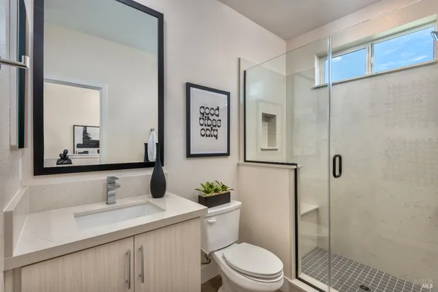 a bathroom with a sink a toilet and shower