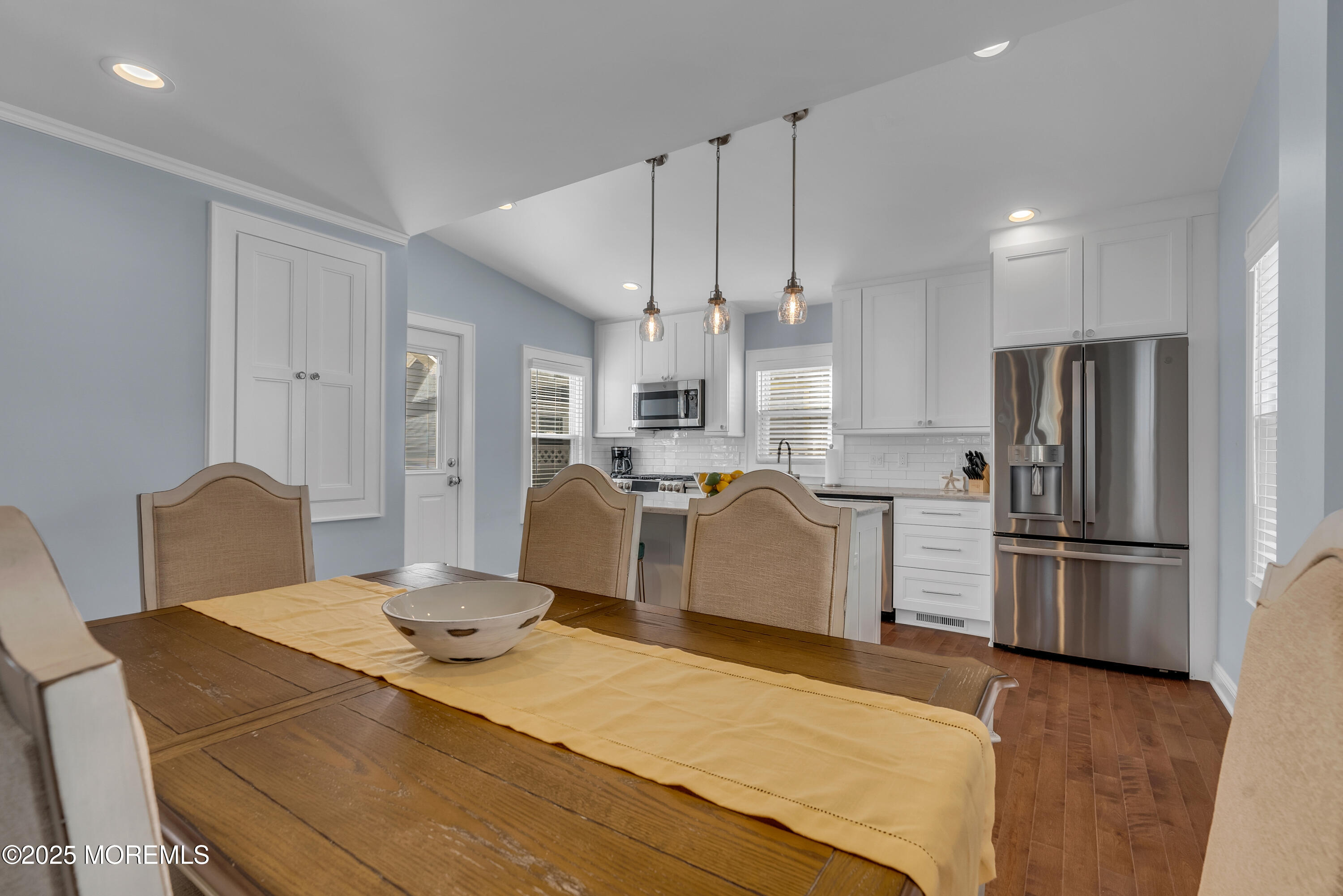 52 Embury Avenue Ocean Grove, NJ 07756 - Photo 20 of 88 a kitchen with stainless steel appliances kitchen island granite countertop a refrigerator a stove a kitchen island a dining table and chairs with wooden floor