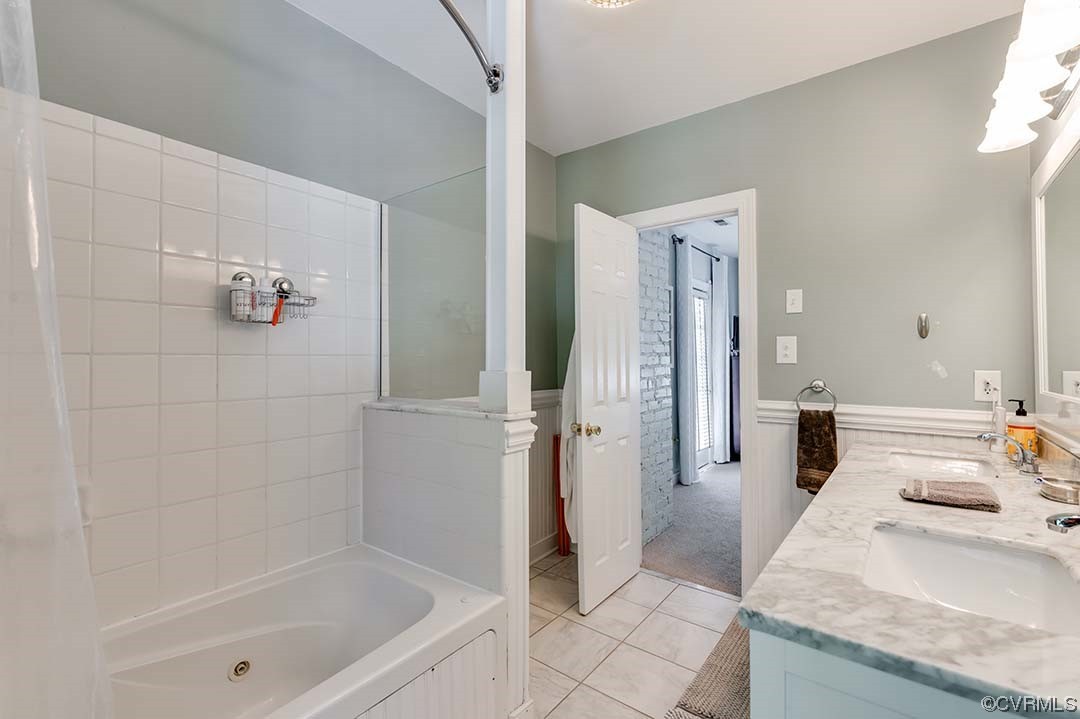 5009 Devonshire Road Richmond, VA 23225 - Photo 25 of 43 a bathroom with a granite countertop sink a mirror a bathtub and shower