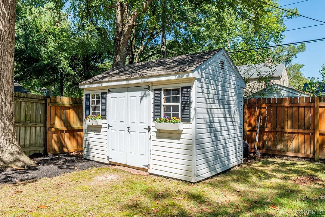 5009 Devonshire Road Richmond, VA 23225 - Photo 40 of 43 a view of a white house with large windows and a large tree