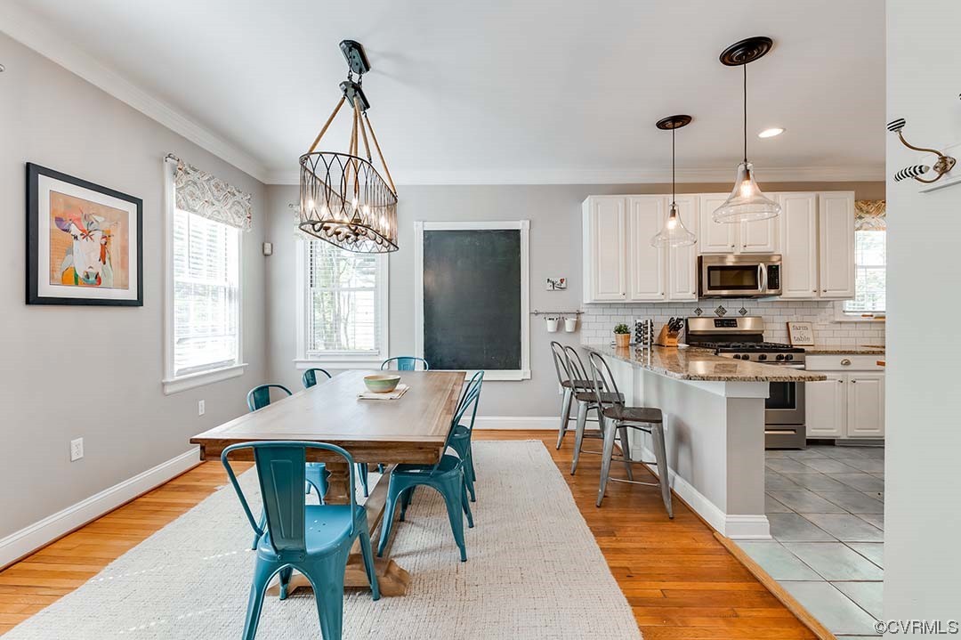 5009 Devonshire Road Richmond, VA 23225 - Photo 6 of 43 a open kitchen with stainless steel appliances granite countertop a stove top oven a sink dishwasher a dining table and chairs with wooden floor