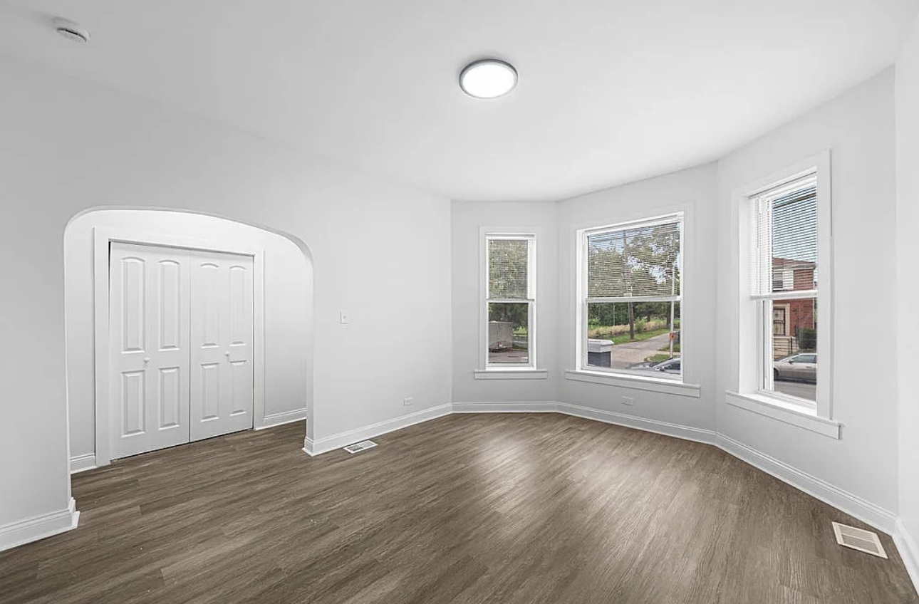 7912 South Ada Street, Unit 1 Chicago, IL 60620 - Photo 2 of 10 an empty room with wooden floor and windows
