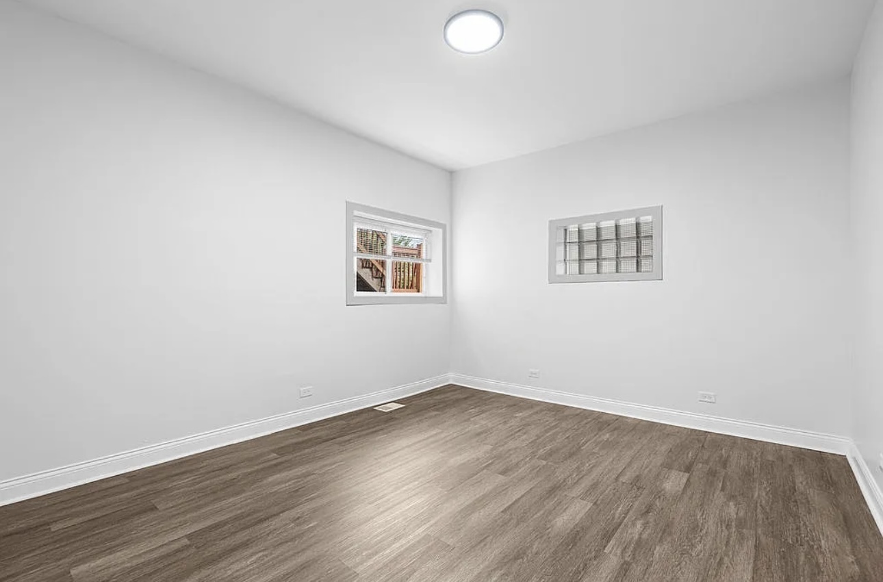 7912 South Ada Street, Unit 1 Chicago, IL 60620 - Photo 4 of 10 an empty room with wooden floor and windows