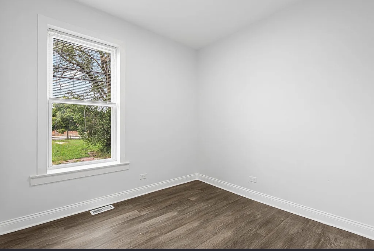 7912 South Ada Street, Unit 1 Chicago, IL 60620 - Photo 7 of 10 an empty room with wooden floor and windows