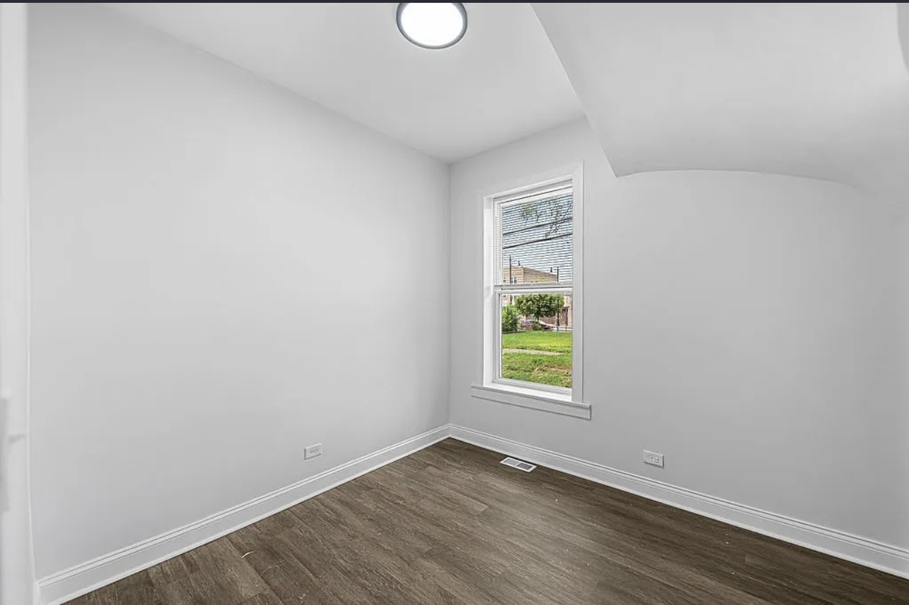 7912 South Ada Street, Unit 1 Chicago, IL 60620 - Photo 9 of 10 a view of an empty room with wooden floor and a window