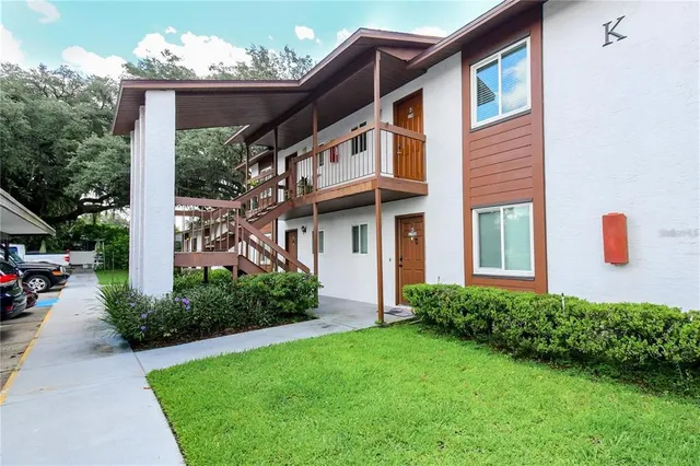 a view of a house with brick walls and a yard with plants
