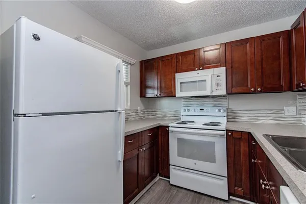 a kitchen with a sink a refrigerator and cabinets