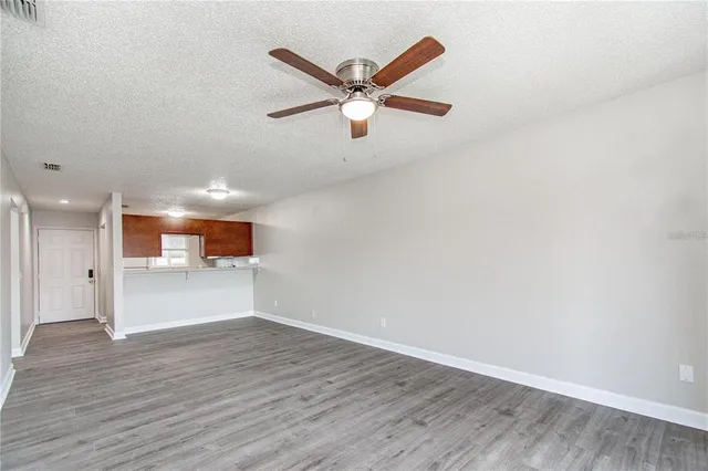 a view of a livingroom with a ceiling fan and wooden floor