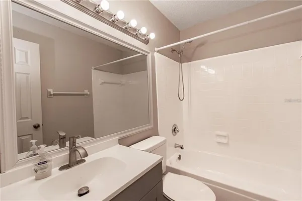 a bathroom with a sink a toilet a mirror and shower