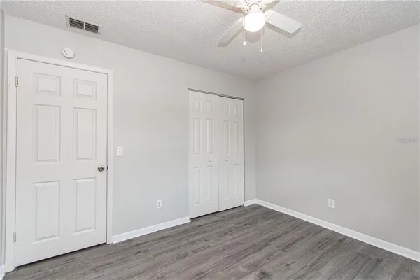a view of an empty room with wooden floor