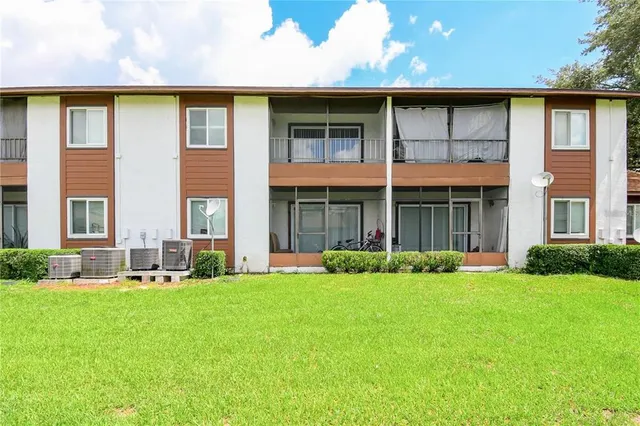 a front view of a brick house with a yard and plants