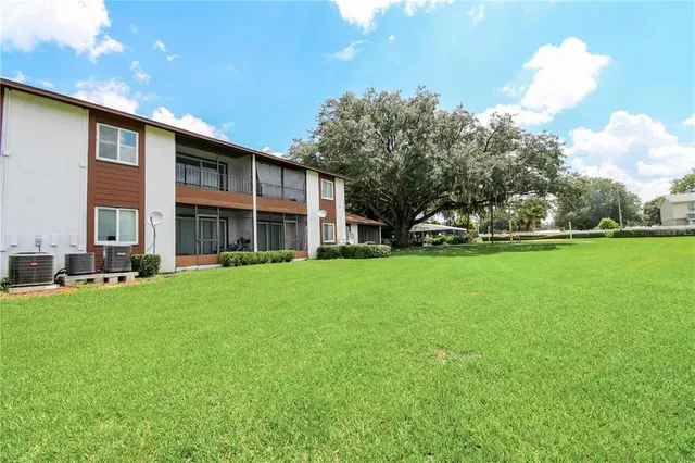 a view of an house with backyard space and balcony