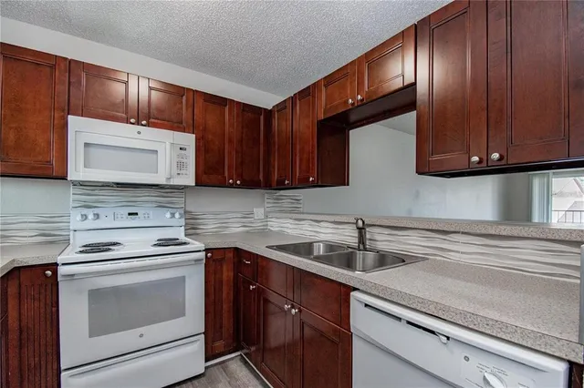 a kitchen with stainless steel appliances granite countertop wooden cabinets a stove a sink and dishwasher