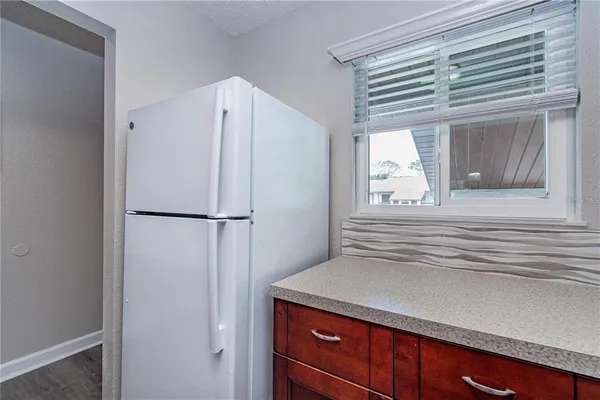 a kitchen with a refrigerator and countertop cabinets
