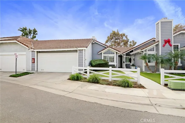 a front view of a house with a yard and potted plants