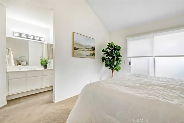 a bedroom with a large bed and a potted plant