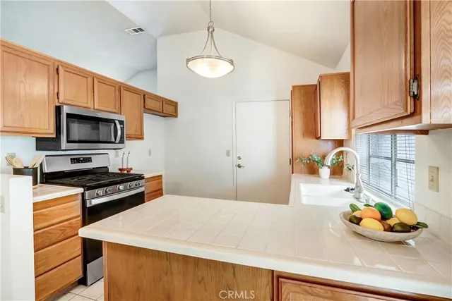 a kitchen with stainless steel appliances a stove microwave and sink
