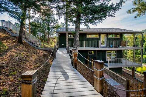 a view of a house with a wooden deck and a large window