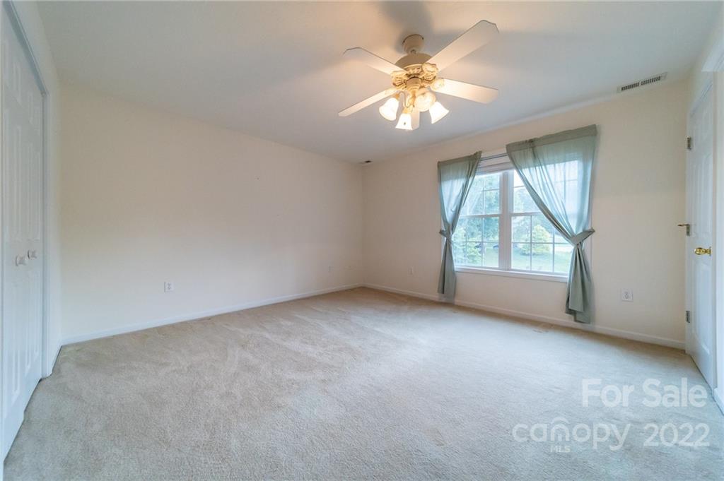 3446 Raintree Drive Hudson, NC 28638 - Photo 15 of 24 an empty room with a chandelier fan and windows