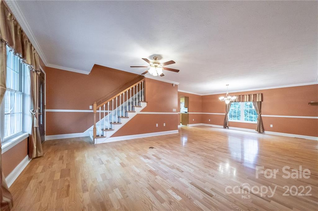 3446 Raintree Drive Hudson, NC 28638 - Photo 4 of 24 a view of a livingroom with wooden floor a ceiling fan and windows
